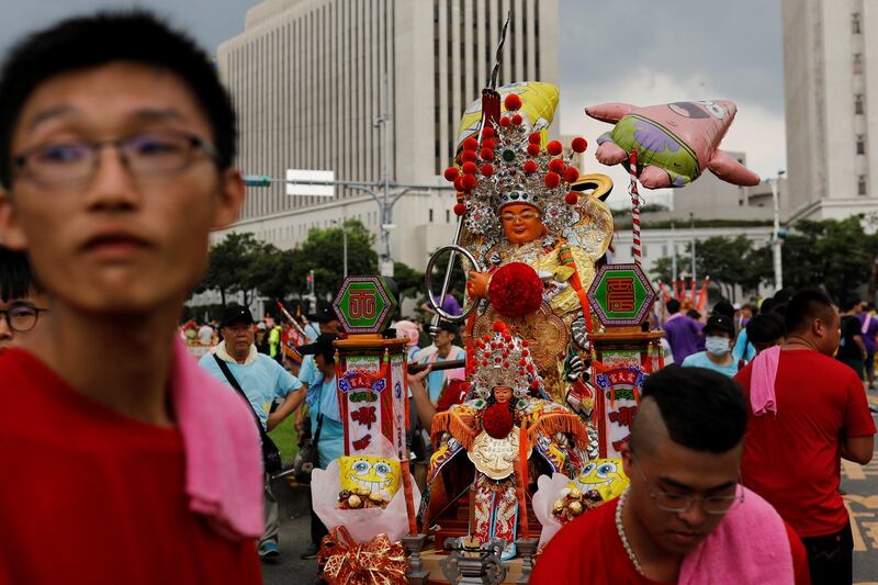 台北，信徒抬着道教女神妈祖和哪咤的雕像参加宗教游行，抗议政府为改善空气品质而减少烧纸的政策。（路透社）