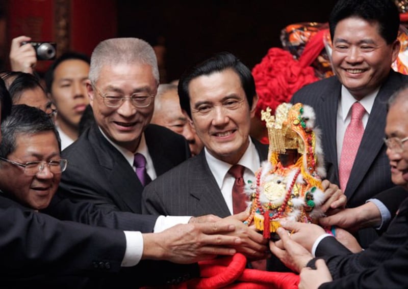 Taiwan's President Ma Ying-jeou (C) and Premier Wu Den-yih (2nd from L) hold a statue of the sea goddess Matsu during the annual pilgrimage in Taichung, Taiwan, in 2010. (Pichi Chuang/Reuters)