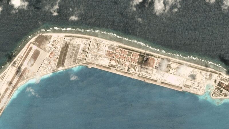 A satellite image taken March 19, 2020, over the Chinese-occupied base at Mischief Reef, showing a large vessel at the quayside. Ship-tracking software shows that Chinese Coastguard ship 5302 stopped there that day.