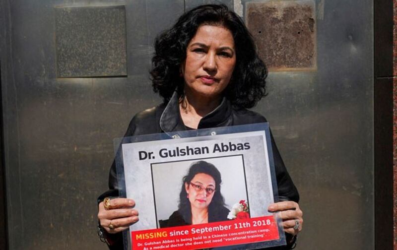 Rushan Abbas, executive director of Campaign for Uyghurs, holds a photo of her sister, Gulshan Abbas, who is imprisoned in Xinjiang, during a rally in New York, March 22, 2021. (Timothy A. Clary/AFP)