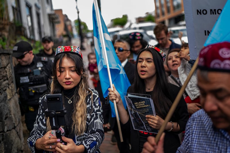 Shahrezad Ghayrat, a journalist with RFA's Uyghur language service, left, live-streams a Uyghur demonstration outside the Thai embassy in Washington, May 5, 2023.