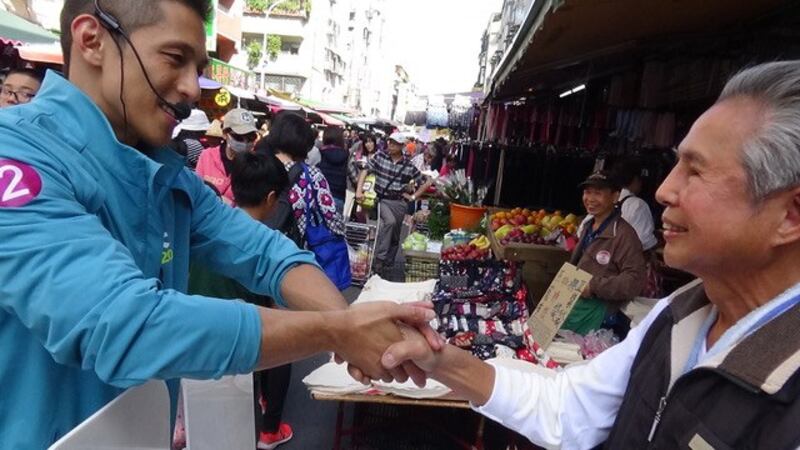 民进党立委候选人吴怡农市场拜票，男女老少通吃。(记者 夏小华摄)