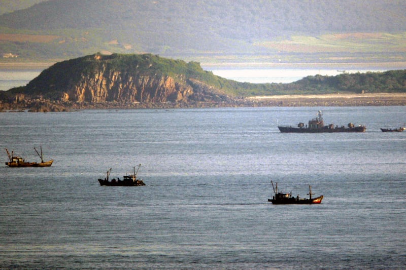 A North Korean navy ship, top right, patrols near fishing boats at South Korea-controlled Yeonpyeong island,  May 31, 2009.