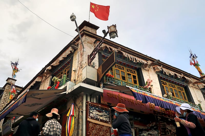 A Chinese flag flies above surveillance cameras on a street near the Jokhang Temple, Lhasa, Tibet, June 1, 2021.