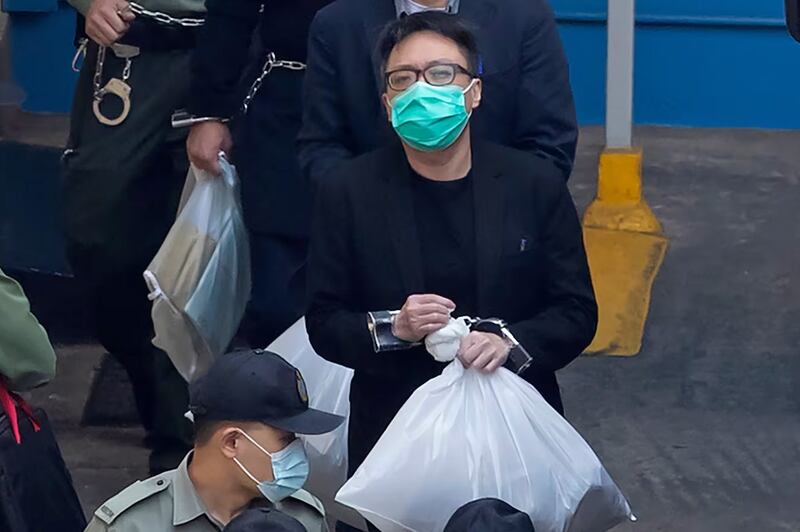 Hong Kong talk show host Tam Tak-chi is escorted, in hand-restraints, to court from Lai Chi Kok Reception Centre, March 2, 2021.