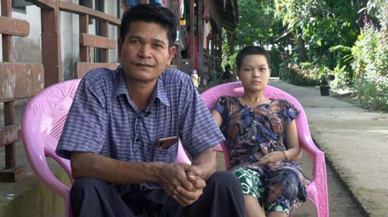 Hnin Yu Hlaing (R) sits beside her father, Maung Phyu Thee, at the Alo Taw Pyay Buddhist monastery compound in Sittwe, western Myanmar's Rakhine state, Oct. 28, 2020.