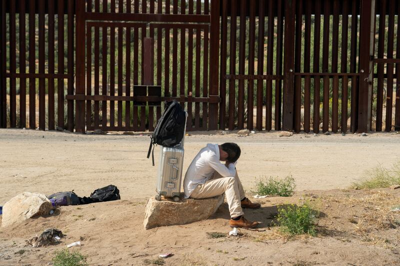 An asylum-seeking migrant from China rests while waiting to be transported by the U.S. Border Patrol after crossing the border from Mexico into the U.S. in Jacumba Hot Springs, California, U.S. June 4, 2024.