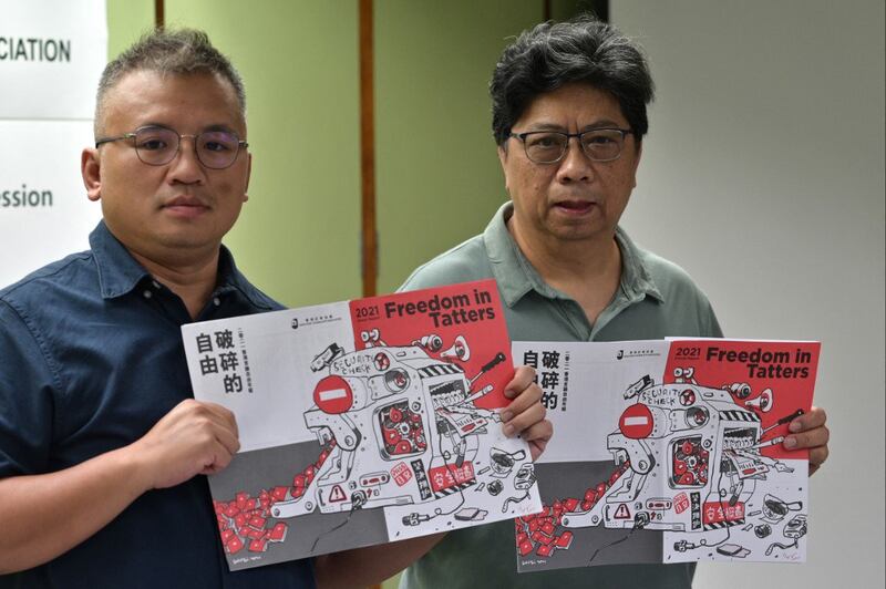 Chairperson of the Hong Kong Journalists Association (HKJA) Ronson Chan (L) and Chris Yeung, chief editor of the annual report, after the release of the organization's annual report “Freedom in Tatters” in Hong Kong, July 15, 2021. Credit: AFP