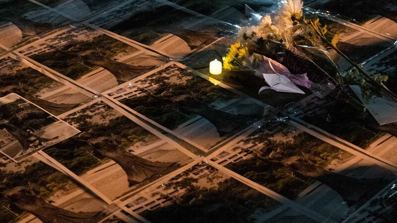 香港中文大学民主女神像被拆后，中大师生在女神像原址空地上放下鲜花、点上烛光悼念。(AFP)