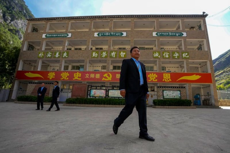 Officials walk at the compound of the Shangri-La Key Boarding School in Dabpa county, Kardze prefecture, in southwest China's Sichuan province, Sept. 5, 2023. (Andy Wong/AP)