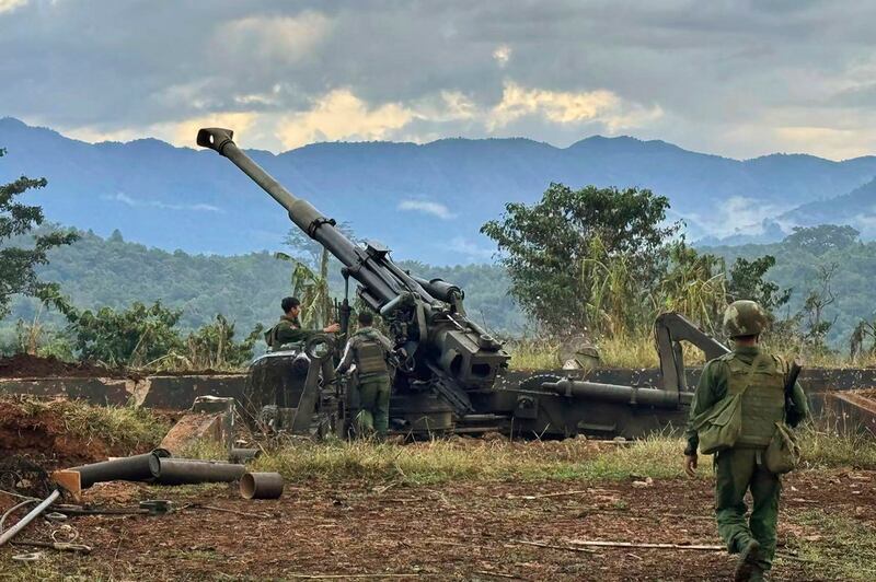 In this Kokang online media provided photo, fighters of Three Brotherhood Alliance check an artillery gun, claimed to have been seized from Myanmar junta outpost on a hill in Hsenwi township, Shan state on Nov. 24, 2023. (The Kokang online media via AP)