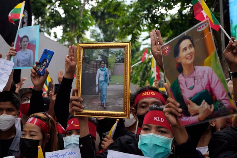 Myanmar nationals living in Thailand hold pictures of deposed Myanmar leader Aung San Suu Kyi as they protest outside Myanmar's embassy in Bangkok, July 26, 2022. Credit: Sakchai Lalit/AP