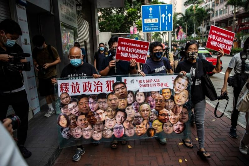 Pro-democracy activists Tsang Kin-shing (L) and Chan Po-Ying (R) demand the release of China's many political prisoners in a rare protest in the Wan Chai district of Hong Kong on China's National Day, Oct. 1, 2021. Credit: AFP