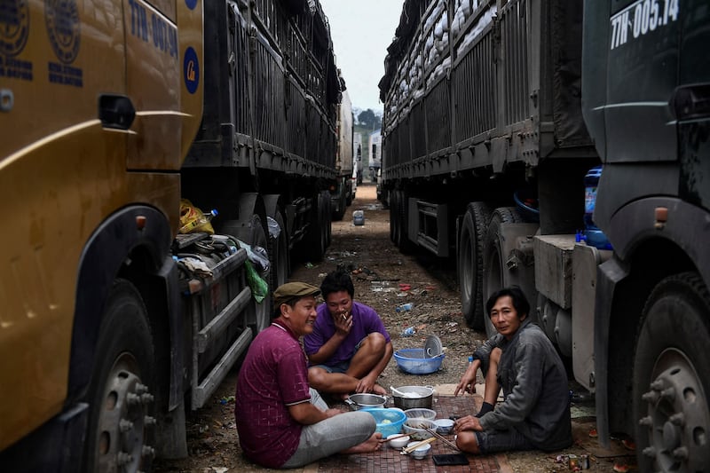 Truck drivers eat lunch at the makeshift parking lot near the Vietnam-China border in Lang Son province on Jan. 7, 2022. Credit: AFP