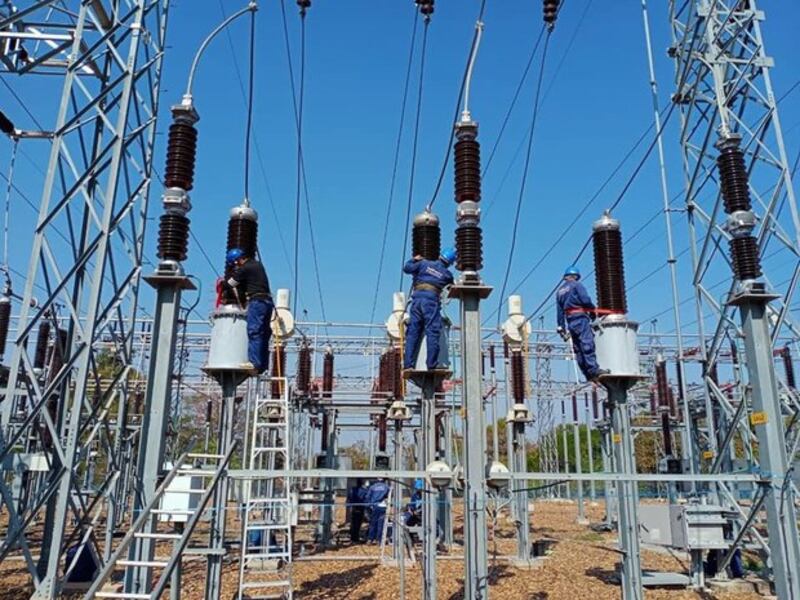 In this March 2020 file photo, employees of the Électricité du Laos (EDL) work on a power line in Vientiane, Laos.