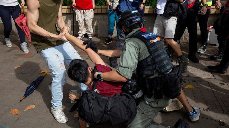 2020年7月1日，香港举行抗议国安法，一名防暴警察试图抓捕一名男子。（AFP）