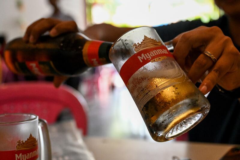 Myanmar Beer, which has been boycotted because sales generate revenue for the junta, is poured in a restaurant in Yangon, March 31, 2022. Credit: AFP