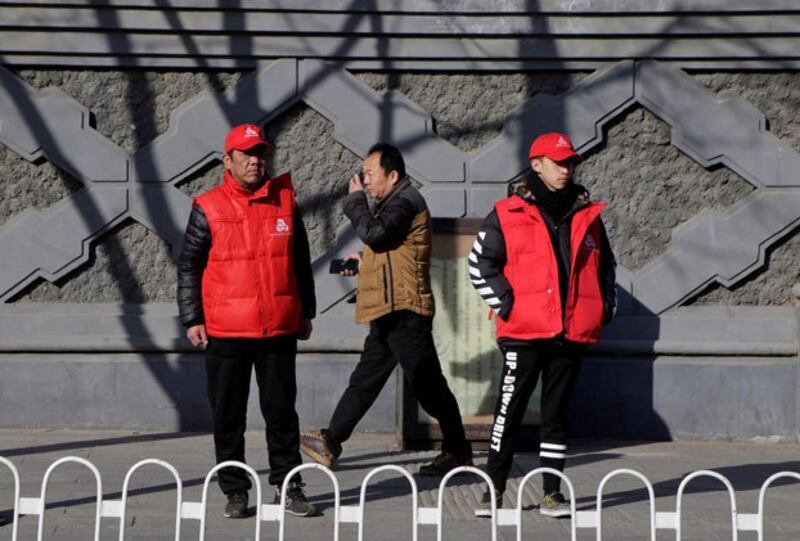 Local residents with red armbands, identifying them as security volunteers, keep watch near Zhongnanhai leadership compound in Beijing, March 1, 2017. (Jason Lee/Reuters)