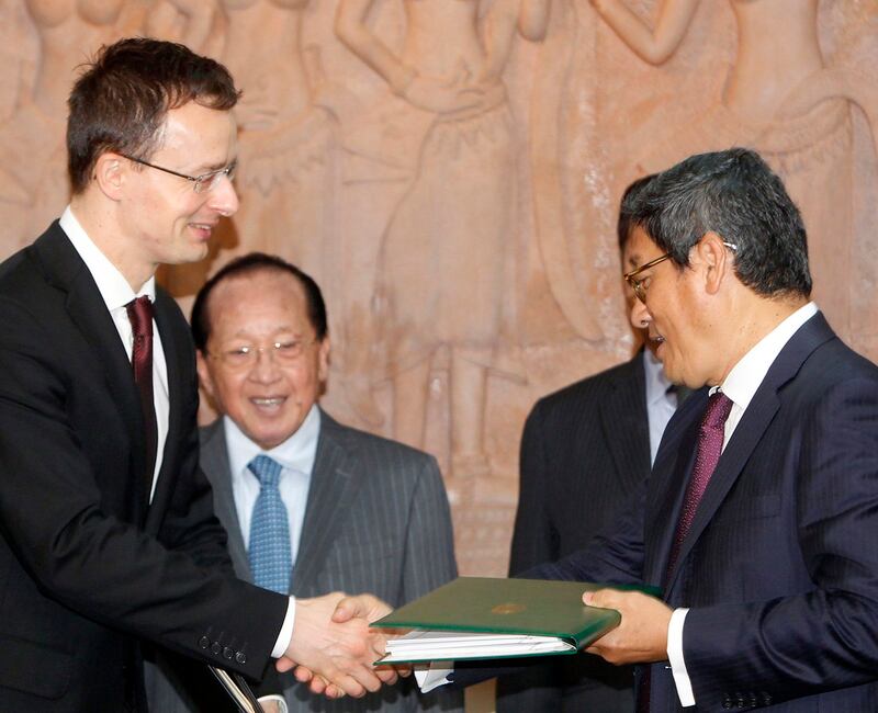 Hungary's Foreign Minister Peter Szijjarto [left] exchanges a document with Sok Chenda Sophea, secretary general of the Council for the Development of Cambodia, after a signing ceremony in Phnom Penh, Cambodia, Jan. 14, 2016. Credit: Heng Sinith/AP