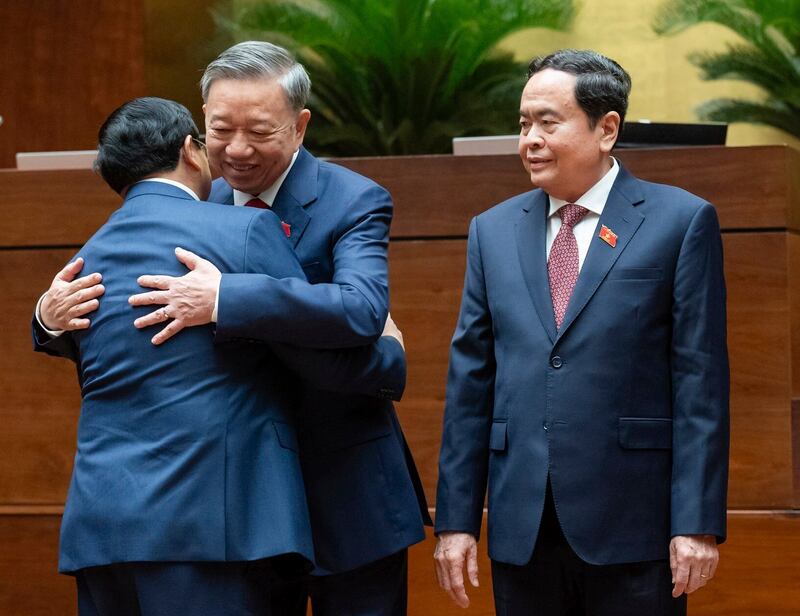 Vietnamese President To Lam, center right, hugs Prime Minister Pham Minh Chinh as National Assembly Chairman Tran Thanh Man looks on after Lam was sworn in as the president at the National Assembly in Hanoi, May 22, 2024. (Nghia Duc/National Assembly via AP)