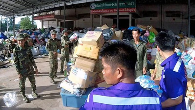 Soldiers and volunteer aid workers staff a warehouse of supplies for Lao villagers displaced by flooding in Paksong district, southwestern Laos' Champassak province, July 28, 2018.