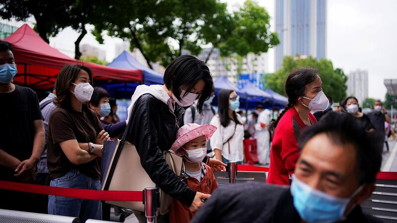 图为2020年5月16日，武汉市戴着口罩的居民排队等候核酸测试。（路透社） 