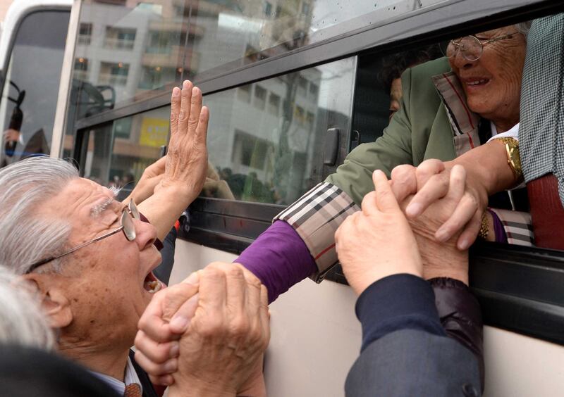 North Koreans (in the bus) grip hands of their South Korean relatives as they bid farewell after a separated family reunion meeting at the Mount Kumgang resort on the North’s southeastern coast on Oct. 22, 2015.