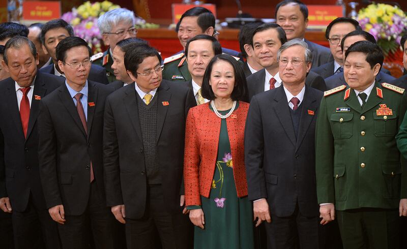 Newly elected Politburo members (L to R) Truong Hoa Binh, Vo Van Thuong, Pham Minh Chinh, Truong Thi Mai, Tran Quoc Vuong and Ngo Xuan Lich pose on the podium along with other new members of the Vietnam Communist Party's central committee at the closing ceremony on the final day of the 12th National Congress of Vietnam's Communist Party in Hanoi on January 28, 2016. Vietnam's top communist leader Nguyen Phu Trong was re-elected on January 27 in a victory for the party's old guard which some fear could slow crucial economic reforms in the fast-growing country.      AFP PHOTO / POOL / HOANG DINH Nam (Photo by HOANG DINH NAM / POOL / AFP)