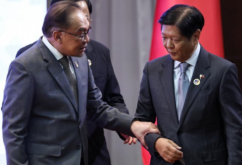 Malaysian Prime Minister Anwar Ibrahim (left) speaks with Philippine President Ferdinand Marcos Jr. as they attend the 27th ASEAN-China Summit at the National Convention Centre in Vientiane, Oct. 10, 2024. [Athit Perawongmetha/Reuters]