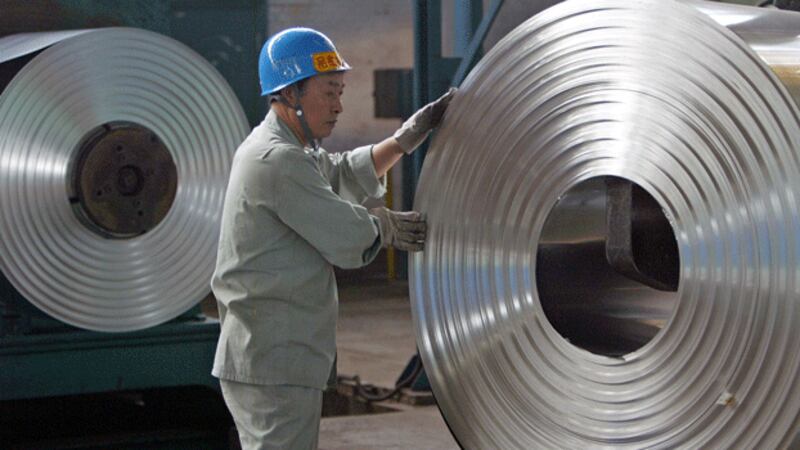 A Chinese worker inspects steel at a cold-rolling mill of the Wuhan Iron & Steel Group on the outskirts of Wuhan, capital of central China's Hubei province, in a file photo.