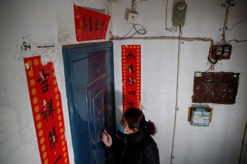 A member of a neighborhood committee knocks on the door to register locals and ask about their travel history in Jiujiang, Jiangxi province, China, during the COVID-19 pandemic, Feb. 2, 2020. Credit: Thomas Peter/Reuters