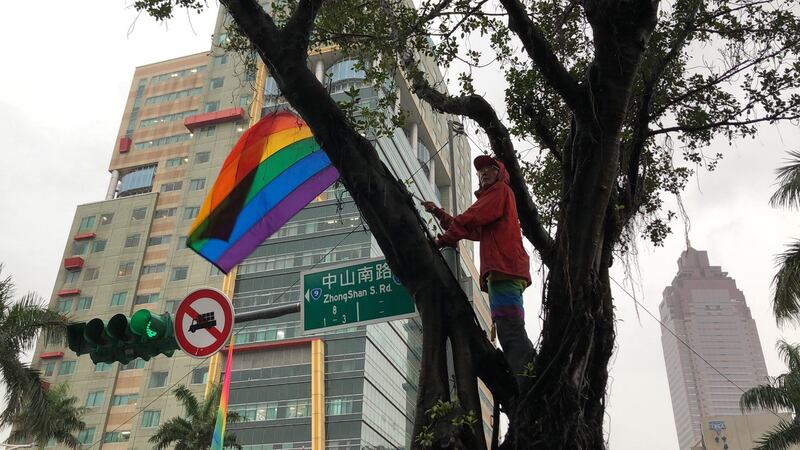 游行现场祁家威总会寻求制高点挥舞彩虹旗。（记者夏小华摄）