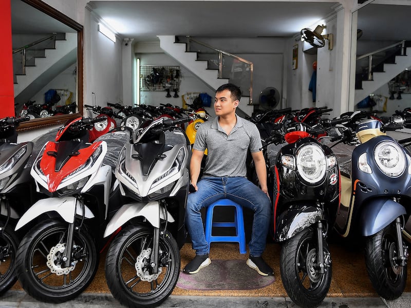 A salesman waits for customers at a motorcycle and scooter showroom in Hanoi, VIetnam,  March 29, 2021.