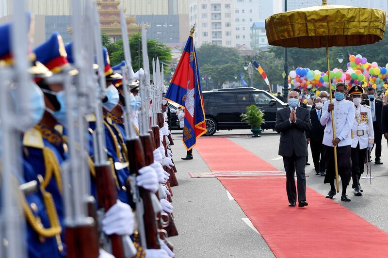 Cambodian King Norodom Sihamoni (R) walks past honor guards during a ceremony marking Cambodia's Independence Day in Phnom Penh, Nov. 9, 2020.