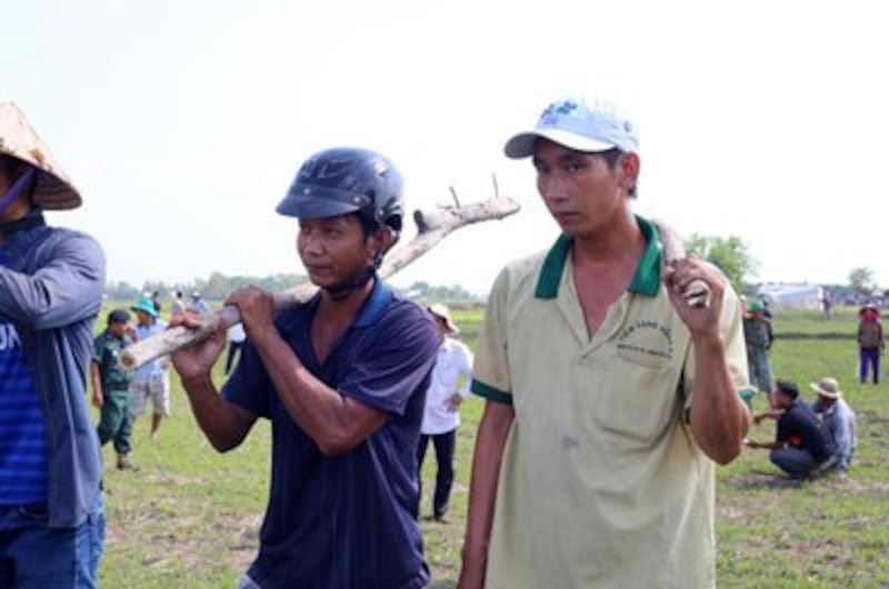 Vietnamese villagers hold sticks during a confrontation with Cambodian activists in Svay Rieng province's Kampong Ro district, June 29, 2015. Credit: RFA