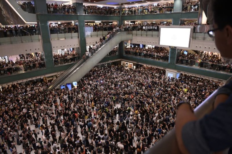 香港民众在一间商场内合唱“愿荣光归香港”。 (法新社)