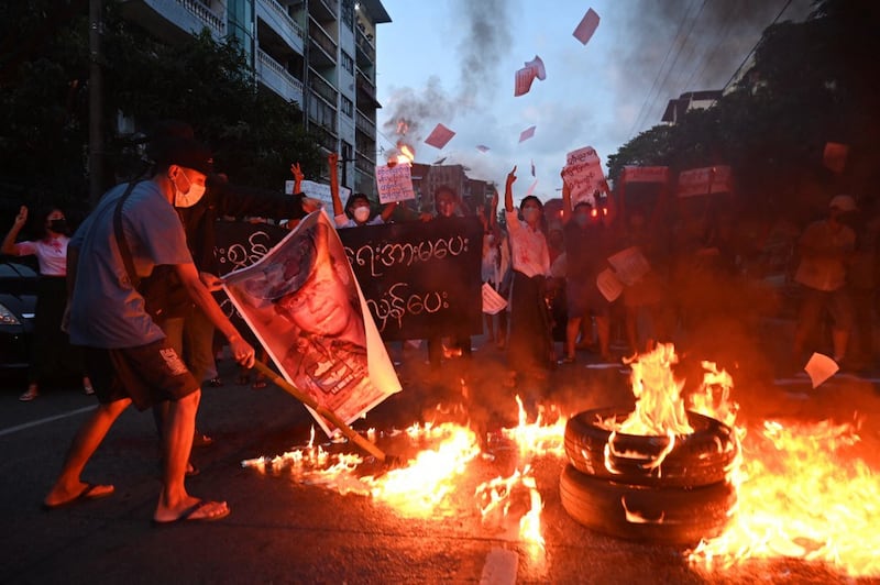 Protesters burn a picture of Myanmar's military chief Min Aung Hlaing during a demonstration against the military coup in Yangon, Nov. 10, 2021. Credit: AFP