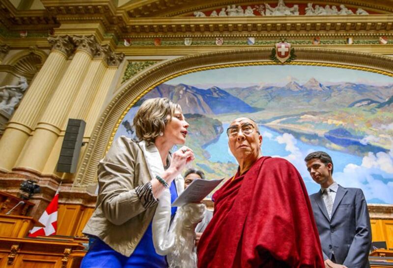 The Dalai Lama listens to an explanation by Swiss politician Maya Graf (L) during a visit to the Swiss Parliament in Bern, Switzerland, April 16, 2013. (Fabrice Coffrini/AFP)