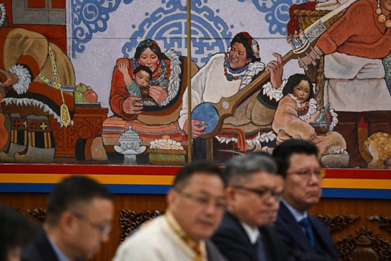 Delegates sit below a decoration in the Tibet Hall of the Great Hall of the People during the Tibet delegation meeting at the National People's Congress at the Great Hall of the People in Beijing, March 6, 2024. (Greg Baker/AFP)