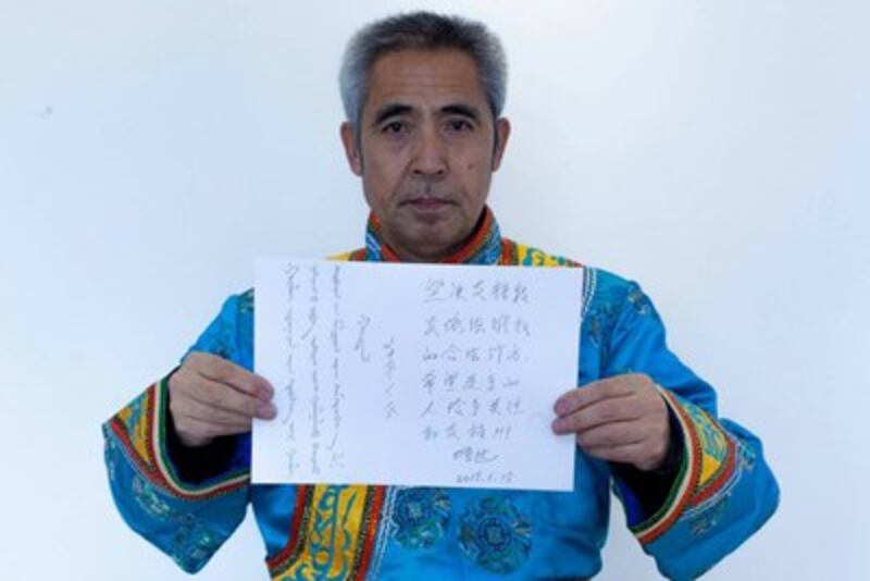 Hada displays a sign expressing support for herders in Mongolian and Chinese, Jan. 15, 2015.