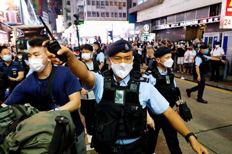 Police officers ask people to leave the area near the closed Victoria Park. (Reuters)