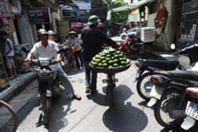 Một người bán trái cây dạo trên đường phố Hà Nội ngày 16 tháng 9 năm 2010. AFP PHOTO / HOANG DINH Nam.