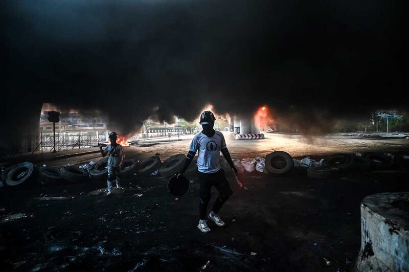 Sometimes the line of defense is augmented by thick, black smoke from burning tires as shown here in Yangon. (AFP)