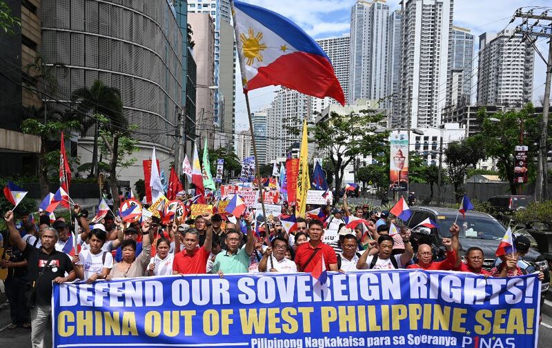 Protesters opposed to China's encroachment in Philippines waters carrying national flags and placards march towards the Chinese consulate in Manila on April 9, 2019. Credit: AFP