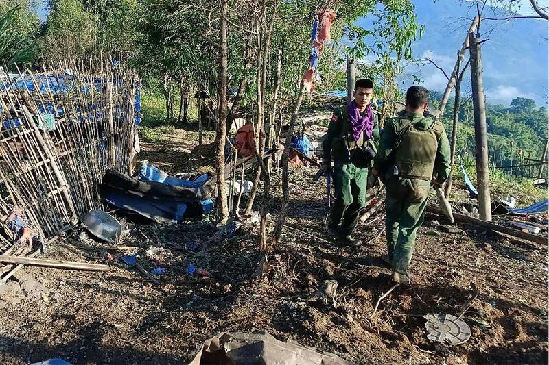 Myanmar National Democratic Alliance Army (MNDAA) fighters walk past a Myanmar military base after seizing it during clashes in Myanmar's northern Shan state, Oct. 28, 2023. (Kokang Information Network via AFP)