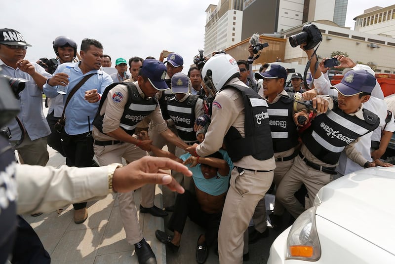 Cambodia security officers clash with a union member near the National Assembly during a protest against the trade union law in Phnom Penh, April 4, 2016. (Samrang Pring/Reuters)