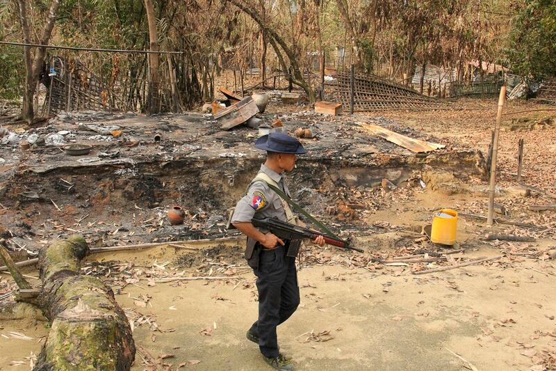 A Myanmar security officer walks past burned Rohingya houses in Ka Nyin Tan village of suburban Maungdaw, northern Rakhine state, Sept. 6, 2017. (AP)