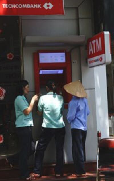 Công nhân viên rút tiền lương từ máy ATM, ảnh minh họa. AFP photo 