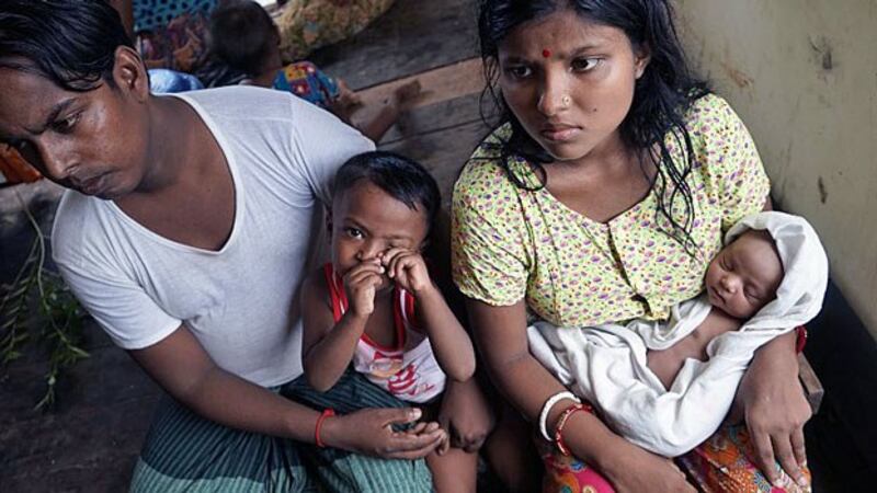 Chaw Shaw Chaw Thee (R), a Hindu woman from Myanmar's Rakhine state, sits with her newborn baby, her husband, and their young son in a shelter for refugees in Sittwe nearly a month after Rohingya militants attacked their Hindu village in the Kha Maung Seik area of northern Rakhine, Sept. 22, 2017.