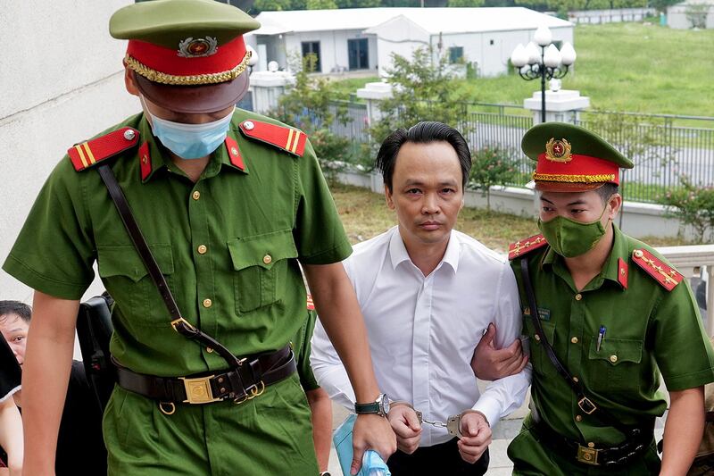 Police escort FLC Group CEO Trinh Van Quyet to court on July 22, 2024, for his trial on fraud charges in Hanoi. (Anh Tuc/AFP)